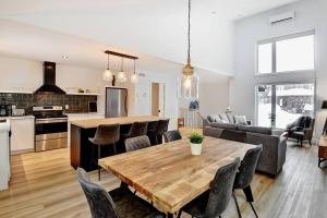 Una cocina y una sala de estar con una mesa y sillas de madera. en 114 Chemin des Ruisselets, en Stoneham