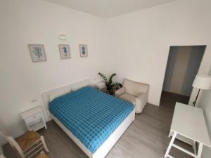 a small bedroom with a bed and a chair at Casa Marina Guesthouse Cagliari in Cagliari