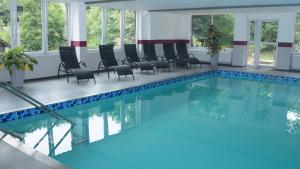 a large swimming pool with chairs in a building at Landgasthof Linkenmühle in Hornbach