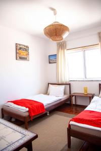 a bedroom with two beds and a chandelier at Penthouse Apartment, City Center in Caldas da Rainha
