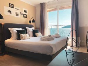a bedroom with a large bed with a large window at Best Western Plus La Corniche in Toulon