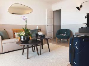 a living room with a couch and tables with flowers at Best Western Plus La Corniche in Toulon