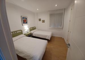 a small room with two beds and a window at Reyno de Baeza in Baeza