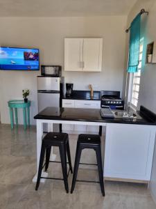 a kitchen with a counter with two stools in it at Bel Ti Plas in The Valley