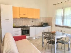 a kitchen with a table and a dining room at Residence S’Oggiastrone in Tanaunella