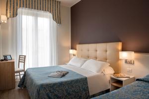 a hotel room with a bed and a window at Hotel Sole Mio in Rimini