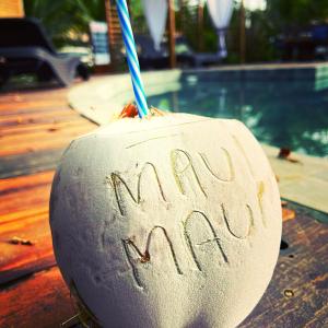 a drink with a straw written in the sand next to a pool at Maui Maui Wellness- Taipu de Fora in Barra Grande