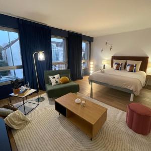 a bedroom with a bed and a living room at Appartement Entre Paris et Disney in Ozoir-la-Ferrière