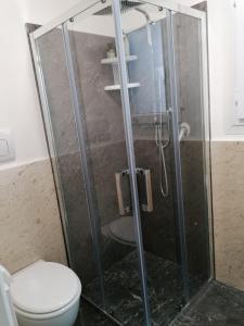 y baño con cabina de ducha y aseo. en Cofano Home, en Custonaci