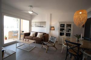 ein Wohnzimmer mit einem Sofa und einem Tisch in der Unterkunft Apartamento en primera línea de playa in Tarifa