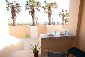 einen Blick vom Balkon eines Zimmers mit Palmen in der Unterkunft Apartamento en primera línea de playa in Tarifa