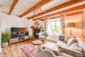 a living room with a couch and a tv at Cosy Bake Cottage, Great Location in Looe, Cornwall in Looe