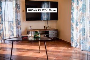 a living room with a glass table and a tv at Nikolina Rab Apartments in Rab