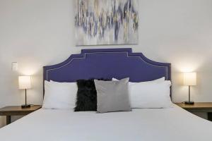 Un dormitorio con una gran cama blanca con dos lámparas. en 3BR Homey & Spacious Apt - Paulina 1S, en Chicago