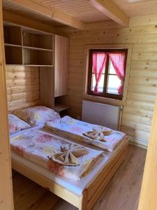 BojnáにあるRanč pod Babicouの木造キャビン内のベッドルーム1室(ベッド2台付)