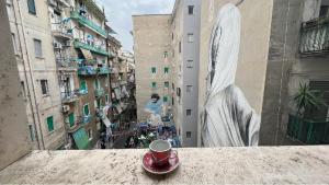 a cup of coffee sitting on a ledge in a city at B&B i Murales in Naples