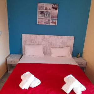 a bedroom with a red bed with two white towels on it at Villa Marianna in Skala Kallirakhis