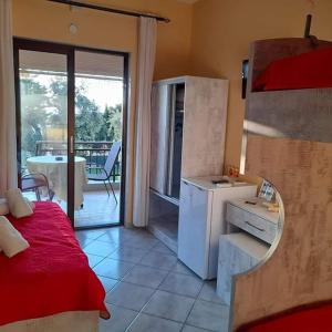 a room with a bed and a kitchen with a balcony at Villa Marianna in Skala Kallirakhis
