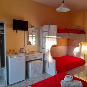 a room with a bunk bed with a kitchen and a refrigerator at Villa Marianna in Skala Kallirakhis