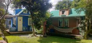 une maison avec un hamac en face de celle-ci dans l'établissement Mini House Park, à Campo Alegre