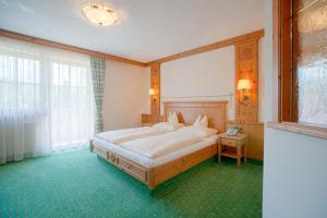 a bedroom with a bed and a large window at Landhaus Grünau in Wals