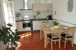 une cuisine avec une table en bois, une table et des chaises dans l'établissement Ferienwohnung am Spreeradweg in Bautzen, à Bautzen