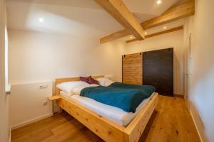 een slaapkamer met een houten bed in een kamer bij Haus Margreiter in Nußdorf am Inn