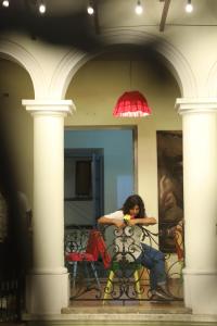 una donna seduta a un tavolo in una stanza di Hostel Cultural Pata y Perro a Tarija