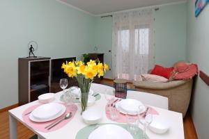 a white dining room table with yellow flowers on it at Starry Night - Smart TV, Extra big bed, big bathtub, private parking, sea view, WIFI, 2bedrooms in Volosko