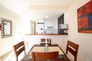 Una cocina y un comedor con una mesa de cristal y sillas. en Los Lances Playa en primera linea, en Tarifa 4 fotos más