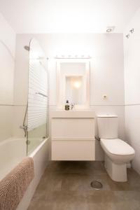 Un baño con inodoro, lavabo y ducha. en Los Lances Playa en primera linea, en Tarifa