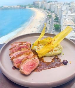 a plate of food with a view of the beach at Rio Othon Palace in Rio de Janeiro