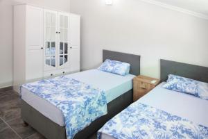 a bedroom with two beds with blue and white sheets at Bluberry Central Fethiye's apartment in Fethiye
