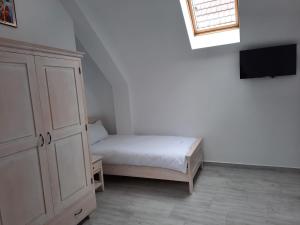 a bedroom with a bed and a cabinet and a television at Casa de oaspeti Maximilian in Codlea