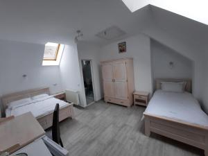 a room with two beds and a cabinet in it at Casa de oaspeti Maximilian in Codlea