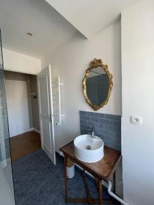 La salle de bains est pourvue d'un lavabo et d'un miroir mural. dans l'établissement Elliott, à Saint-Malo
