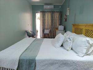 1 dormitorio con 1 cama grande con almohadas blancas en Ebenezer Self Catering, en Groblersdal