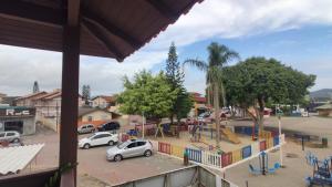 - une vue sur une aire de jeux avec des voitures garées dans un parking dans l'établissement Studio na praça da Lagoa, pertinho de tudo!, à Florianópolis