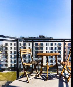 a table and chairs on a balcony with a view at Bliżej Morza AON Apartament Gdańsk in Gdańsk