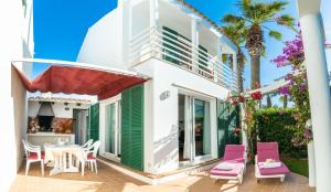 Casa con patio con mesa y sillas rosas en Villa Blanc, en Sa Caleta