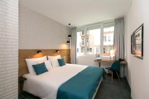 a hotel room with a large bed and a desk at Roombach Hotel Budapest Center in Budapest