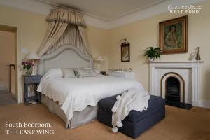 a bedroom with a large bed and a fireplace at Enchanted Retreats at West Ford Devon in South Molton