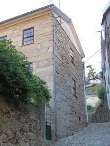 un edificio de piedra con una tubería en el costado en Casa Das Lages, en Alvoco da Serra