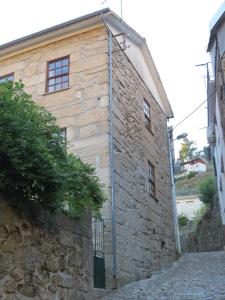 a stone building with a pipe on the side of it at Casa Das Lages in Alvoco da Serra