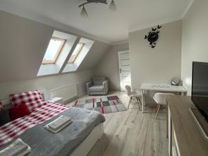 a bedroom with a bed and a table and a desk at Mieszkanie Giżycko in Giżycko