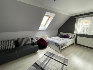 a bedroom with a bed and a couch and a window at Mieszkanie Giżycko in Giżycko