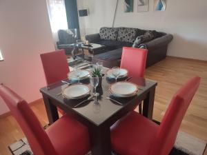 a dining room with a table and red chairs at Antoni Apartment in Skopje