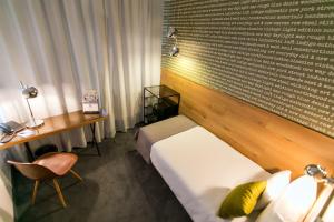 a hotel room with a bed and a desk and a desk at Roombach Hotel Budapest Center in Budapest