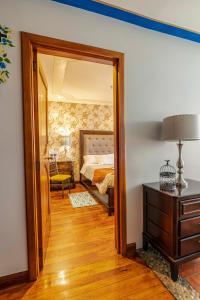 a bedroom with a bed and a mirror and a dresser at Hotel Azul de la Plaza in Cuenca