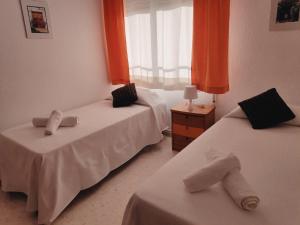 Duas camas num quarto com cortinas cor de laranja em Victoria Home Córdoba em Córdoba
